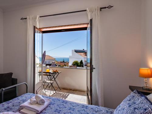 a bedroom with a bed and a view of a balcony at Nº57 House - Ribamar in Santo Isidoro