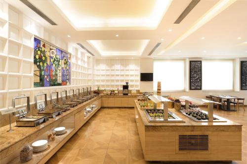 a restaurant with a buffet line in a large room at Lemon Tree Hotel Whitefield, Bengaluru in Bengaluru