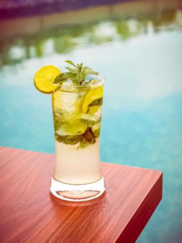 a drink sitting on a table with a lemon slice at Lemon Tree Hotel Whitefield, Bengaluru in Bengaluru