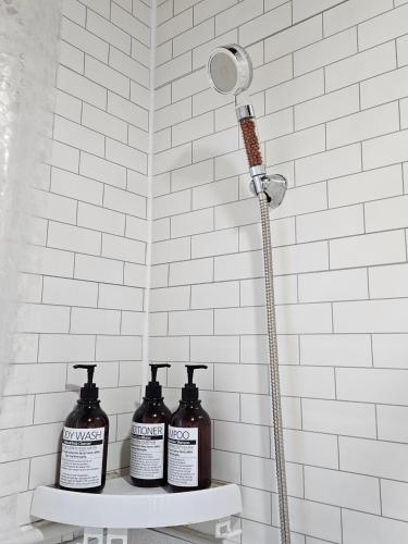 a shower with three bottles on a shelf in a bathroom at Tov Stay Atti in Pyeongtaek