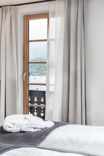 a bedroom with a bed and a window at Biohotel Gralhof in Weissensee