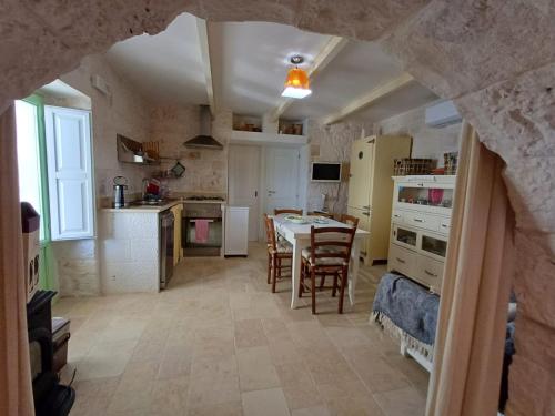 a kitchen and dining room with a table and chairs at trullo fino in Cisternino