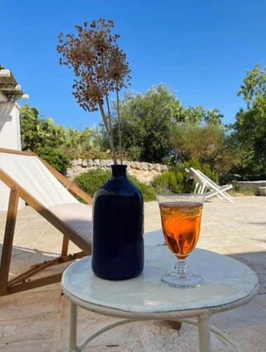 a vase and a drink on a table with a vase at trullo fino in Cisternino