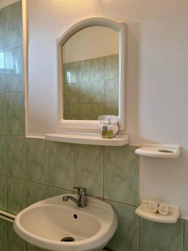 a bathroom with a sink and a mirror at Casa Elenisse in 2 Mai
