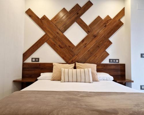 a bedroom with a wooden headboard and a bed at Hostal Remoña in Espinama