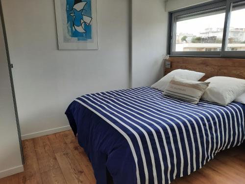 une chambre avec un lit avec une couverture rayée bleue et blanche dans l'établissement One bedroom apartment Palm Beach, à Cannes