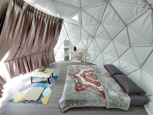 a bedroom with a large bed in a glass wall at Ploy&Praew โดม 2 in Ban Sop Mae Klang