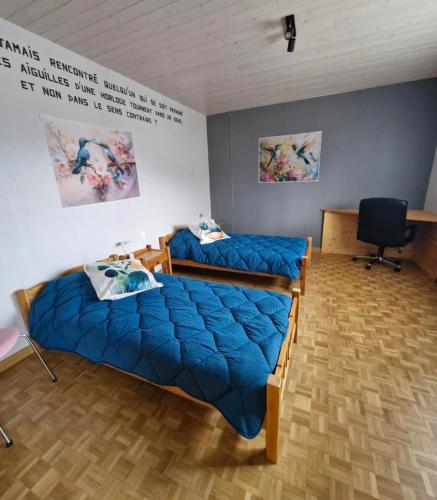 une chambre avec deux lits et une chaise dedans dans l'établissement Deux chambres confortables, à Morbier