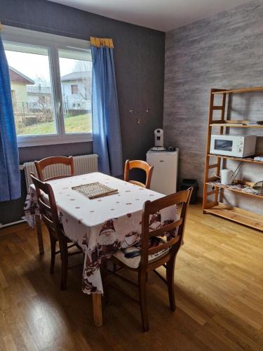 une salle à manger avec une table et des chaises et une fenêtre dans l'établissement Deux chambres confortables, à Morbier