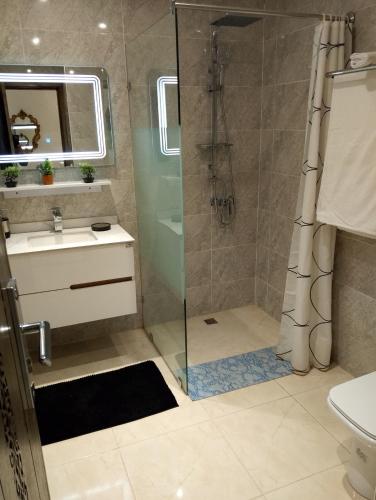a bathroom with a shower and a sink at TheHive Residence in Fès