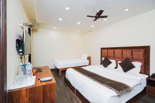 a bedroom with a large white bed and a table at Hotel Atlantis Continental in New Delhi