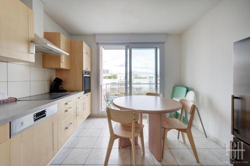 une cuisine avec une table et des chaises et une fenêtre dans l'établissement Grand appartement hyper centre,4 chambres, parking, à Tours