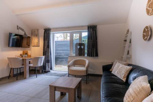 a living room with a couch and a table at Hello Zeeland - Vakantiehuis Wijngaardstraat 12A in Domburg