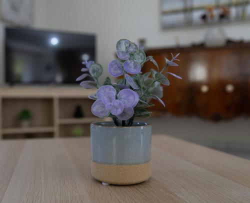 a small vase with purple flowers sitting on a table at Poulakis House in Asini