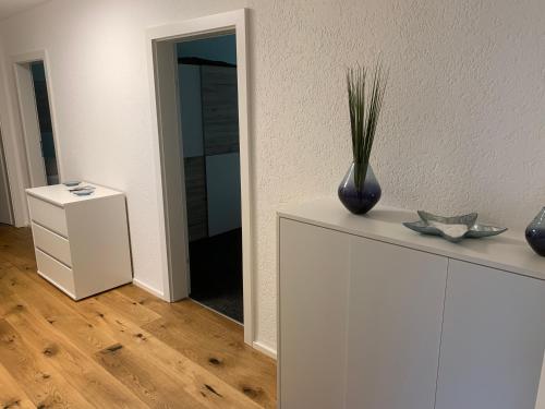 un jarrón sobre un armario blanco con espejo en Luxury Apartements, en Hohenems