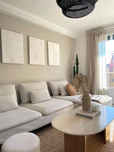 un salon avec un canapé blanc et une table dans l'établissement Nice T2 with balcony - near beach, à Cannes