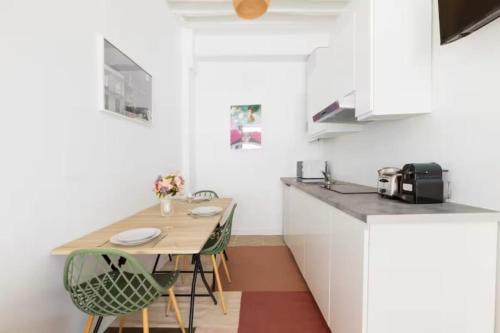 une cuisine avec une table et des chaises dans une pièce dans l'établissement Charming apartment near Gare de l'Est, à Paris