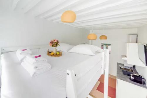 une chambre blanche avec un lit et une table dans l'établissement Charming apartment near Gare de l'Est, à Paris