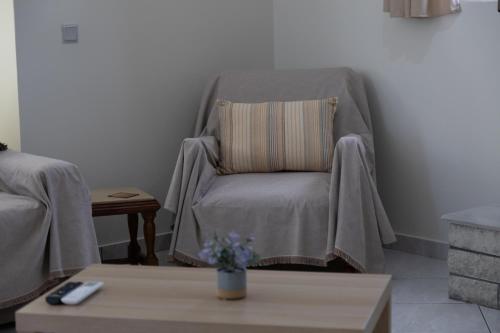 a living room with a chair with a blanket on it at Poulakis House in Asini