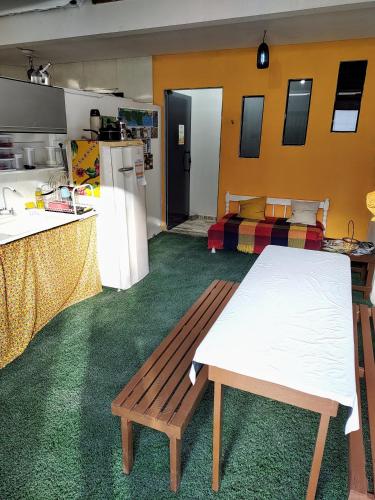 Zimmer mit einer Küche, einem Tisch und einem Sofa in der Unterkunft Qt "Oxê" in Maragogi