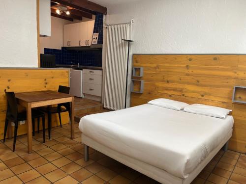 une chambre avec un lit et une table et une cuisine dans l'établissement Villa Liberté, à Villejuif