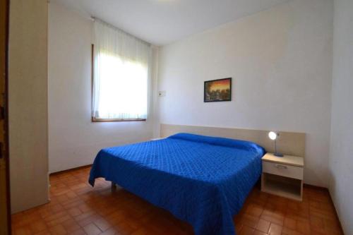 a bedroom with a blue bed and a window at Raffaella in Bibione