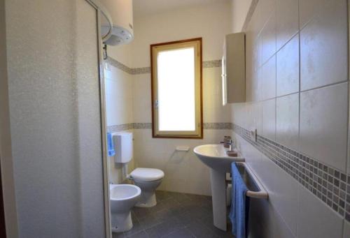 a bathroom with two toilets and a sink and a window at Raffaella in Bibione