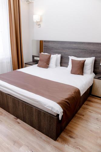 a bedroom with a large bed with a wooden headboard at Infinity Plaza Hotel in Atyraū