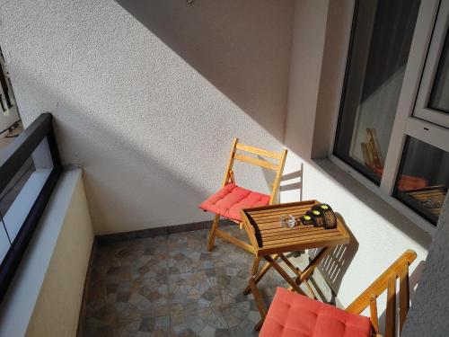 a small balcony with a chair and a table at Tea Studio Apartments in Niš