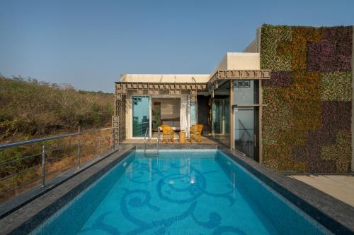 a swimming pool on the roof of a house at SaffronStays Nautica in Harnai
