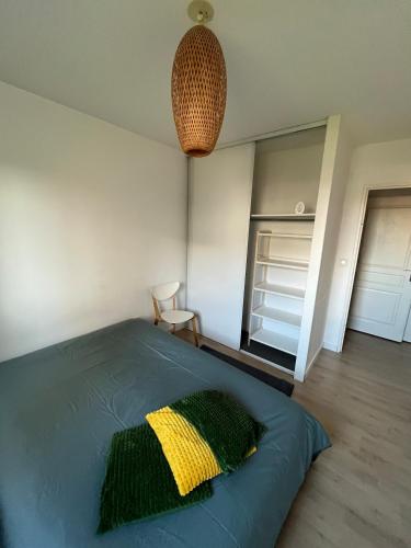 - une chambre avec un lit doté d'un oreiller jaune et vert dans l'établissement Bright and spacious 2 bedroom with balcony, à Wasquehal