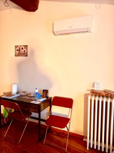 a desk with a chair and a radiator in a room at Chambres d'hôtes Sous L'Olivier in Trausse