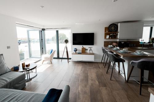 a living room with a couch and a table with chairs at Coast Beachfront GF 6 guests dog friendly apartment in Southbourne