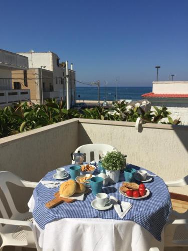 una mesa azul y blanca con comida en el balcón en Lighthouse Villino, en Torre Canne