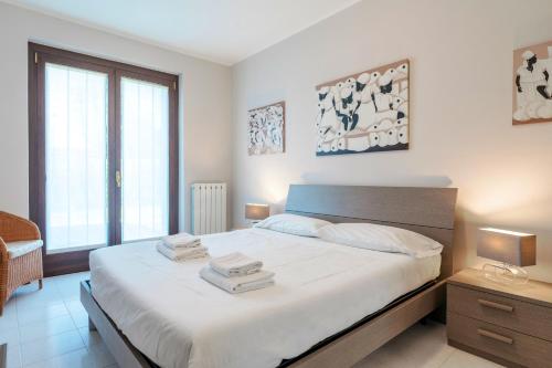 una camera da letto con un letto con due asciugamani sopra di APARTMENTS BLITZ - Regarda Travel a Lazise