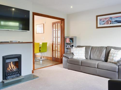 a living room with a couch and a fireplace at Briar Rigg in Keswick
