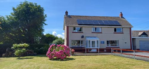 ein Haus mit Solarzellen auf dem Dach in der Unterkunft Pendine Sands Guest House in Pendine
