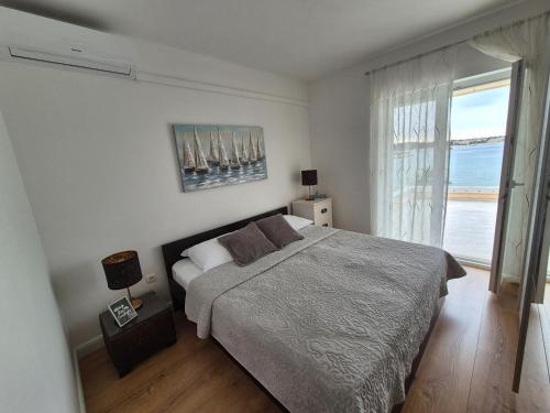 a bedroom with a bed and a large window at Apartment Danijela No. 2 in Novalja