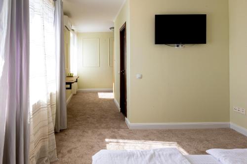 a room with a television on the wall and a hallway at Pension Bella Vista in Sighişoara