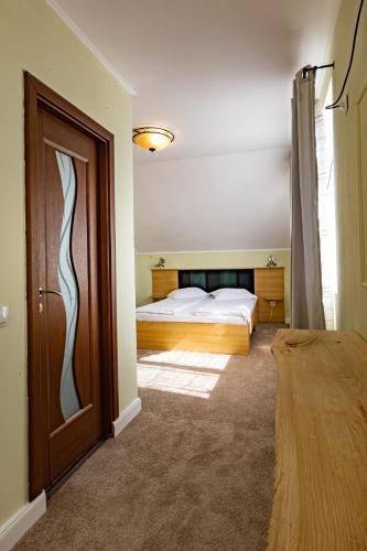a bedroom with a bed and a door with a window at Pension Bella Vista in Sighişoara
