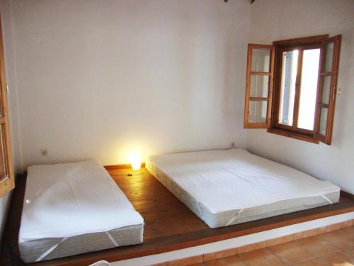 two beds in a room with a lamp and a window at Reina's house by the sea in Akti Salonikiou