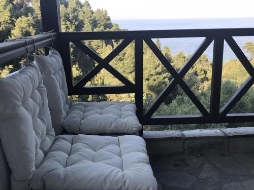 a row of white mattresses on a balcony with a view at Reina's house by the sea in Akti Salonikiou