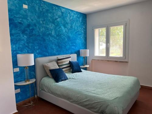 - une chambre bleue avec un lit aux murs bleus dans l'établissement L'Hermitage- Monte Argentario, à Monte Argentario