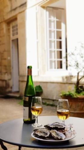 une table avec deux verres de vin et une bouteille dans l'établissement 1738 - T1 Bis Corderie Royale RDC hyper Centre, à Rochefort