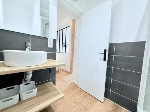 une salle de bain avec un lavabo et un miroir dans l'établissement 1738 - T1 Bis Corderie Royale RDC hyper Centre, à Rochefort