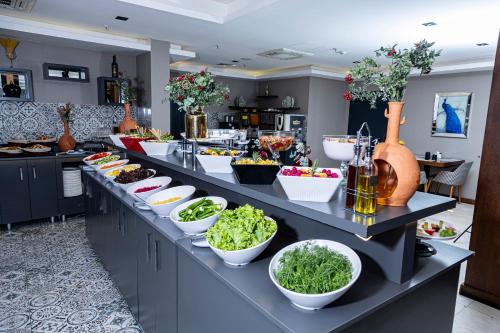 a buffet line with bowls of food in a kitchen at Royal Termal Hotel in Bursa