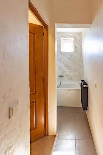 a bathroom with a door and a bath tub at Pension Bella Vista in Sighişoara