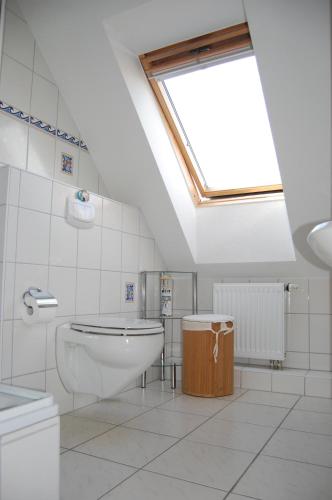 a bathroom with a toilet and a skylight at Gästehaus am Fischerweg in Lauterbach