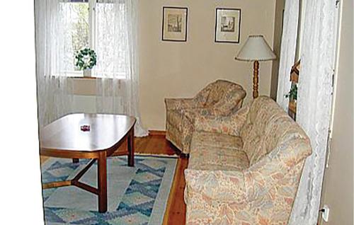 a living room with a couch and a table at Stunning Home In Ljungby With Lake View in Bolmstad