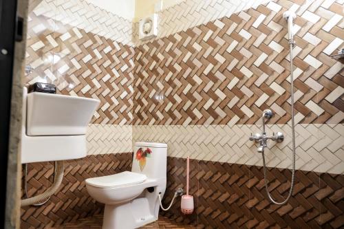 a bathroom with a toilet and a shower at Evara Homestay in Mararikulam